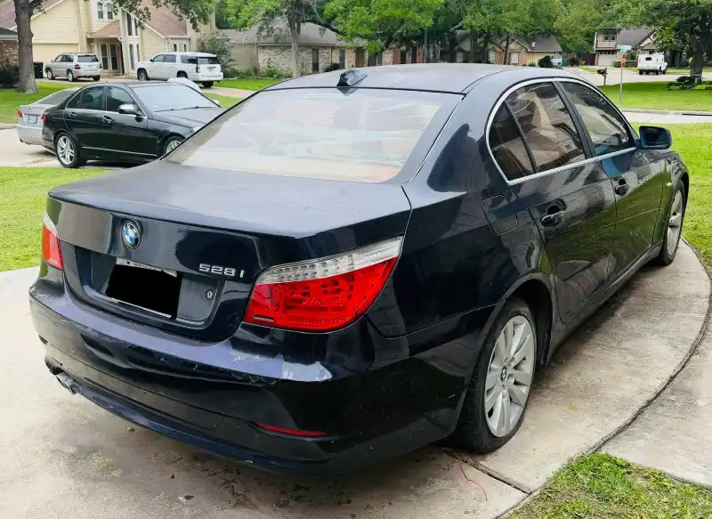 Black BMW sedan parked in a Sugar Land, TX driveway for as-is junk car pickup by Zeus Cash For Junk Cars