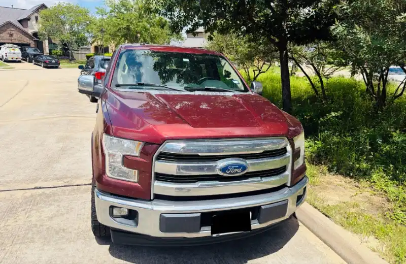 Camioneta Ford F-150 de color rojo estacionada en una zona residencial en The Woodlands, TX, lista para ser evaluada por Zeus Cash For Junk Cars.