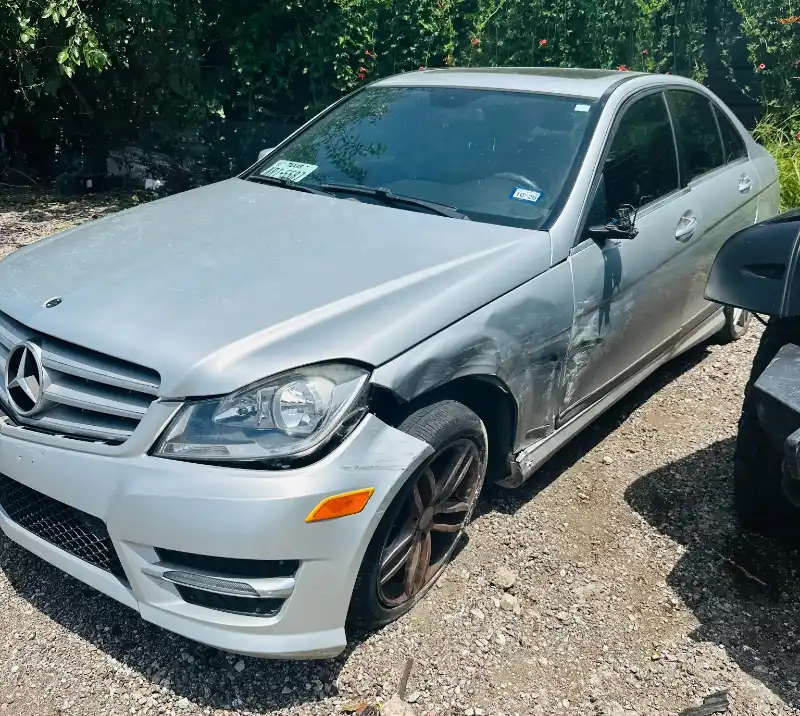 Damaged silver Mercedes sedan parked in League City, TX before vehicle pickup.