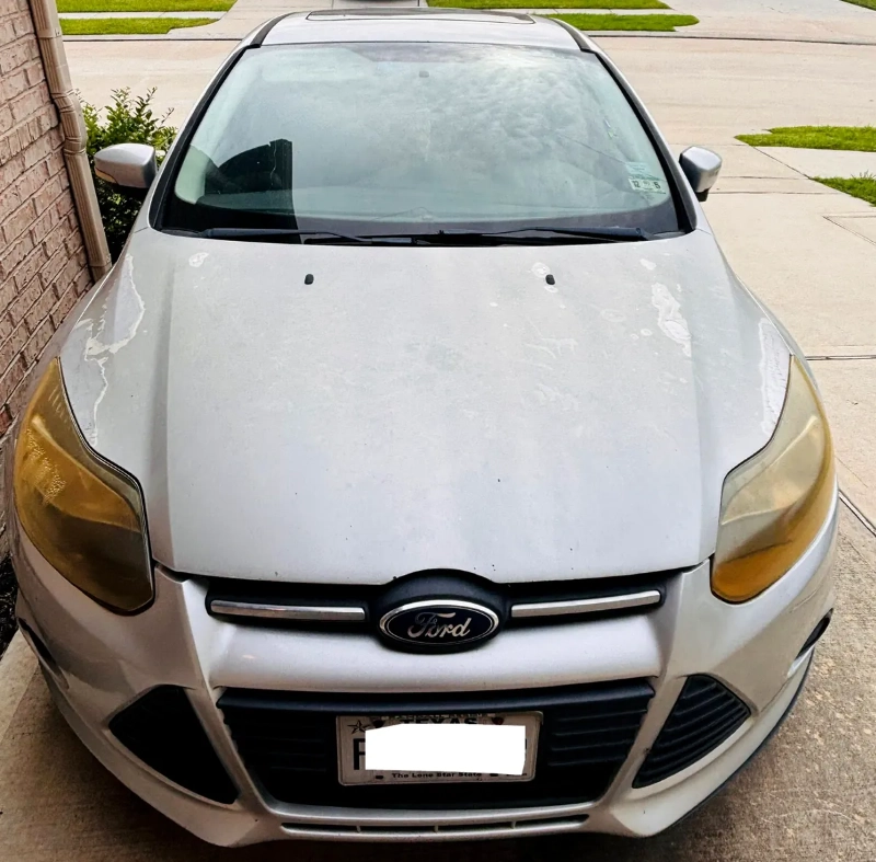 Front view of a silver Ford Focus parked in a driveway in Kingwood Texas ready for junk car removal