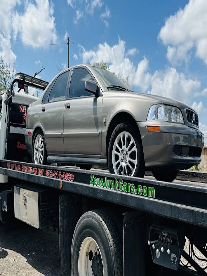 sedan loaded on tow truck in Houston for junk car pickup with free towing