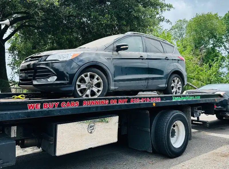 Black Ford SUV on a flatbed tow truck for junk car pickup in The Woodlands, TX.
