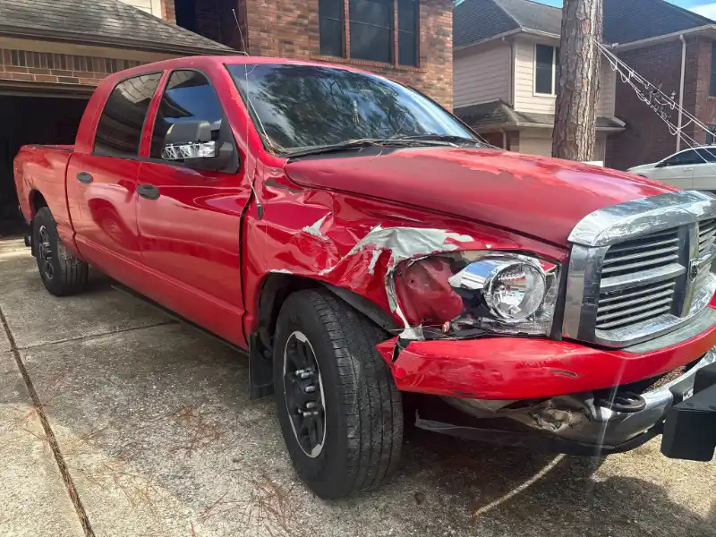 Red Dodge Ram pickup with front-end damage.