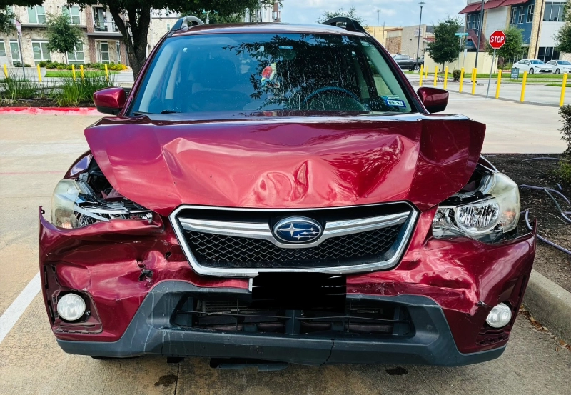 Red Subaru Crosstrek with front-end collision damage parked outdoors.