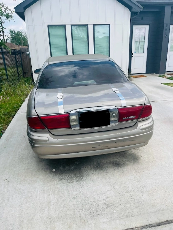 Tan Buick LeSabre parked in a Houston driveway, ready to be sold as a junk car for cash.