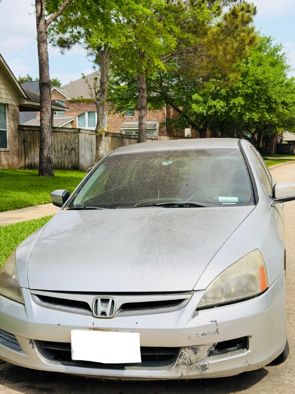 Non-running Honda Accord with front bumper damage parked in a Houston neighborhood ready to be sold as-is