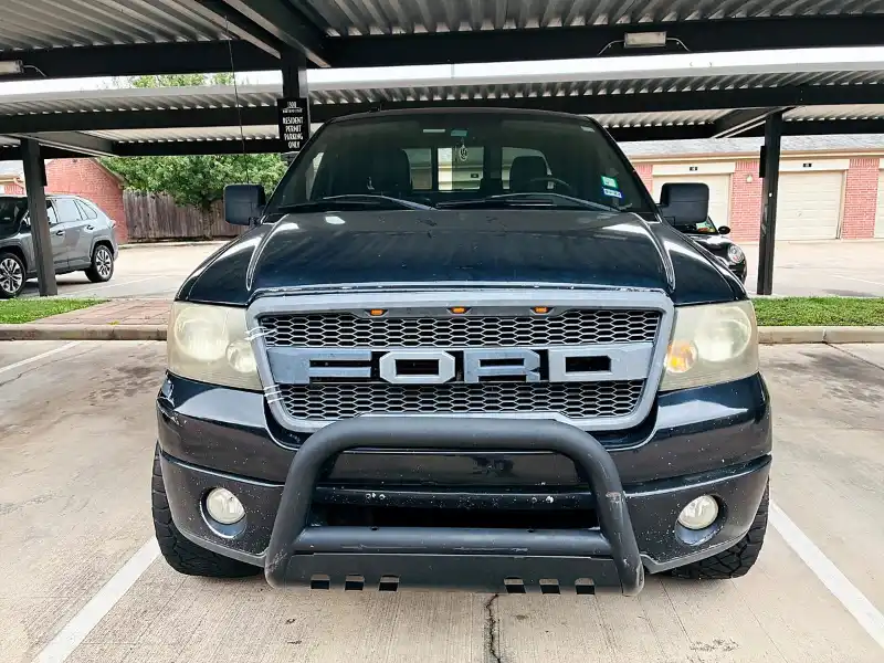 Unwanted Ford pickup parked under an apartment carport in Tomball, TX