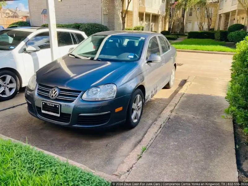 Auto gris estacionado en cochera residencial en Kingwood, TX, listo para ser comprado por Zeus Cash For Junk Cars.