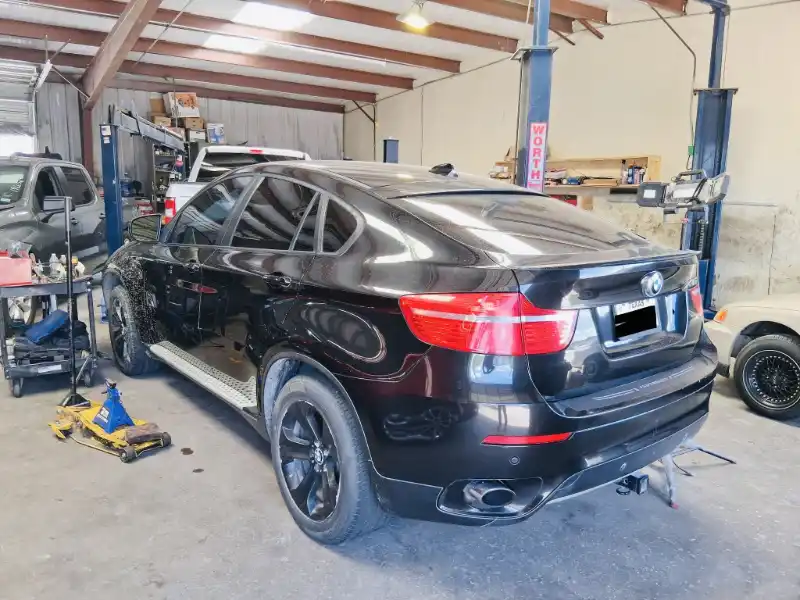 Camioneta negra con fallas mecánicas en un taller, disponible para vender en Katy, TX.